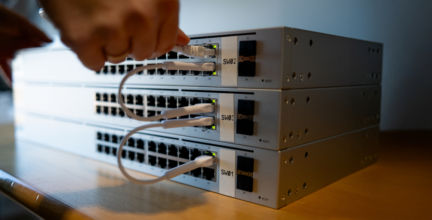 Tre gråa servrar med kablar som sätts i.